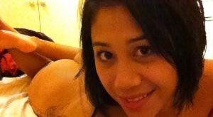 Selfie jeune métisse coquine allongée sur son lit